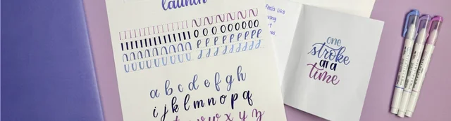 Hand-lettering practice sheets and brush pens