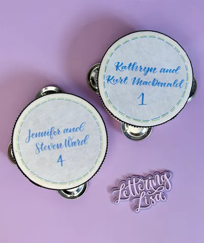 Hand-lettered tambourine table markers